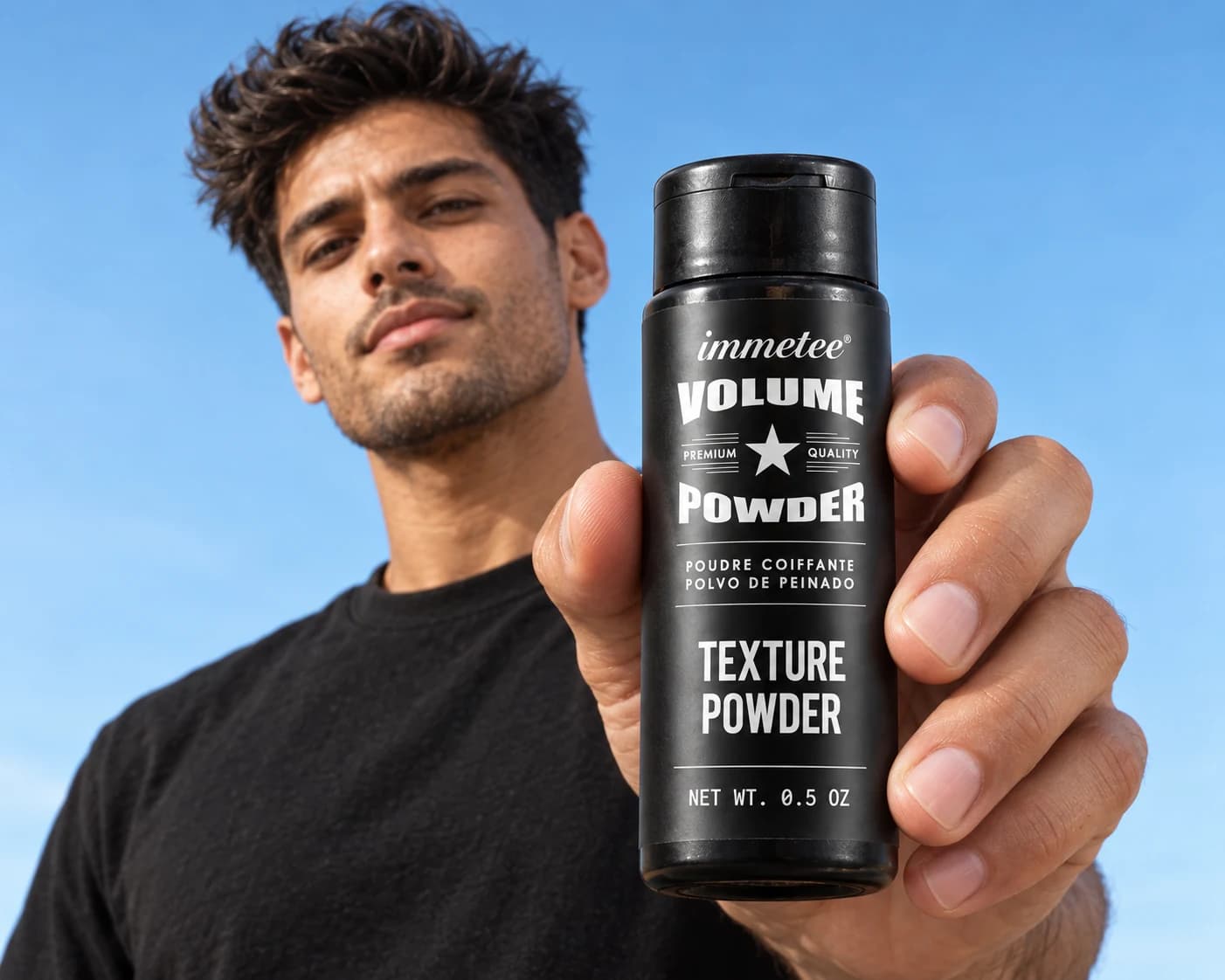 A man with textured hair holding an immetee Texture Powder bottle toward the camera